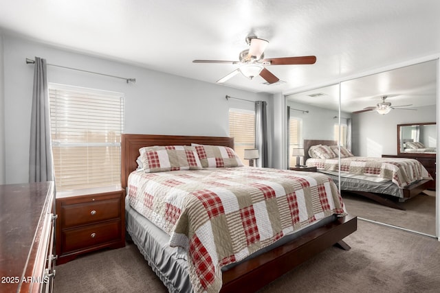 bedroom with dark colored carpet, ceiling fan, and a closet