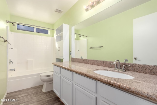 full bathroom with vanity, hardwood / wood-style floors,  shower combination, and toilet