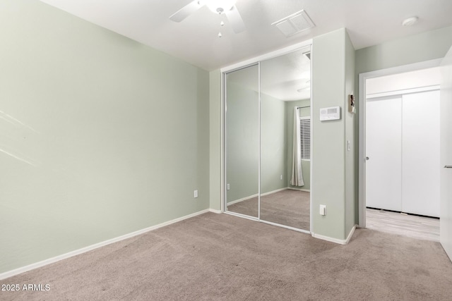 unfurnished bedroom featuring light colored carpet and ceiling fan