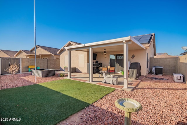 back of property with central AC, solar panels, a lawn, ceiling fan, and a patio