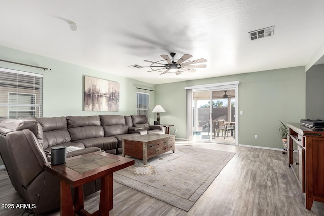 living room featuring light hardwood / wood-style floors and ceiling fan