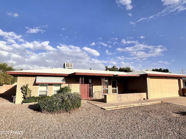 single story home featuring a garage, concrete driveway, and brick siding