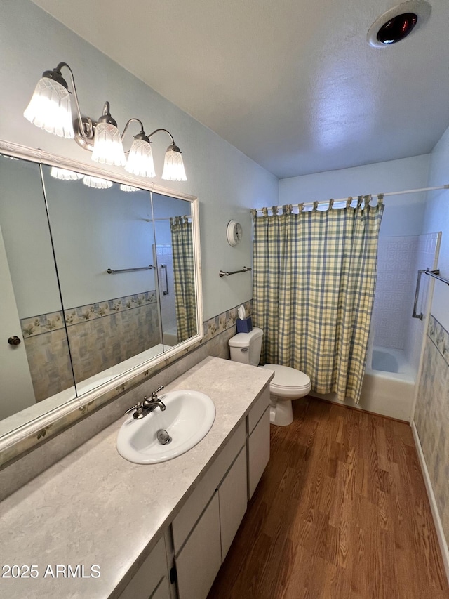 full bathroom with toilet, vanity, wood finished floors, and shower / tub combo with curtain