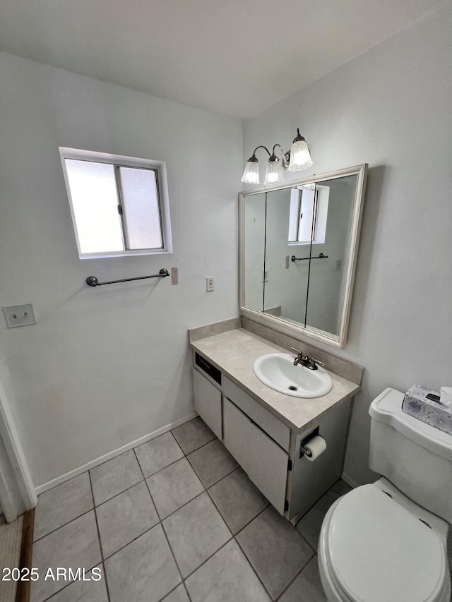 bathroom with toilet, vanity, baseboards, and tile patterned floors