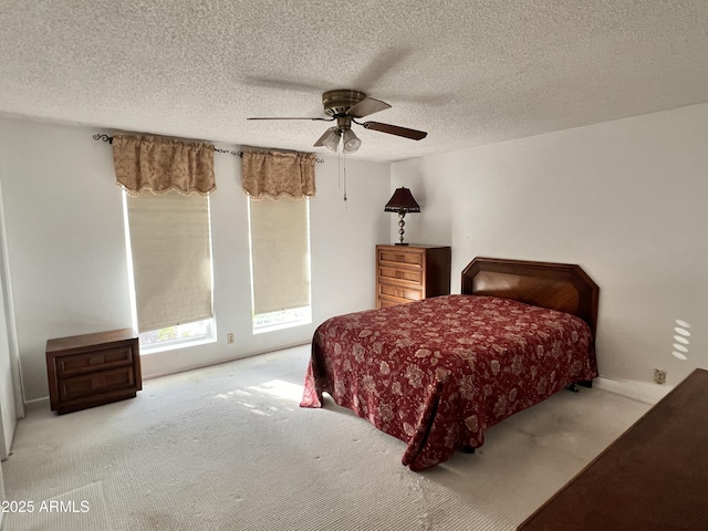 bedroom featuring a textured ceiling, a ceiling fan, and carpet flooring