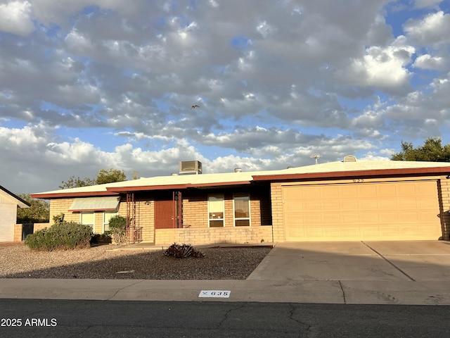 single story home featuring concrete driveway, brick siding, and an attached garage