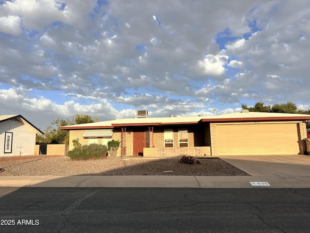 single story home with a garage, brick siding, and driveway