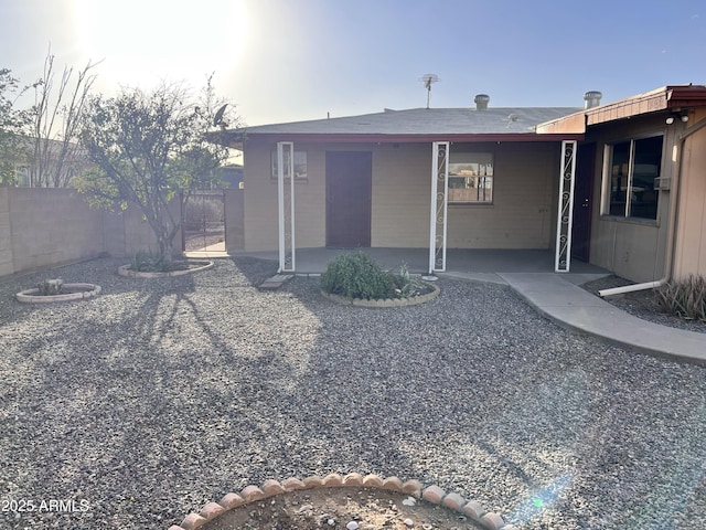 back of property with fence and a patio