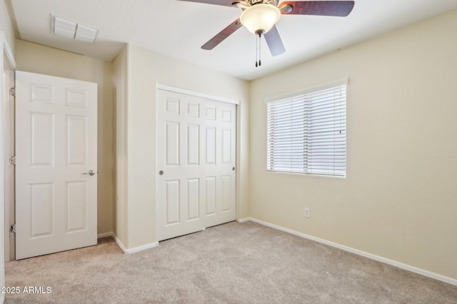 unfurnished bedroom with ceiling fan, a closet, and light carpet