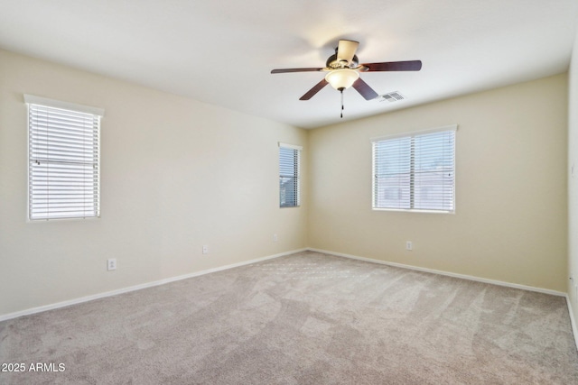 carpeted empty room featuring a wealth of natural light and ceiling fan