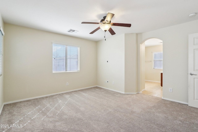 spare room featuring light carpet and ceiling fan