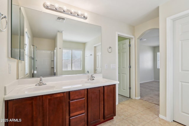 bathroom with tile patterned floors, a healthy amount of sunlight, an enclosed shower, and vanity