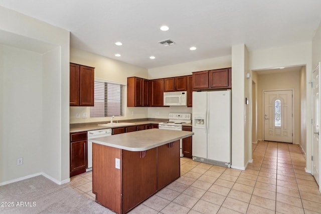 kitchen with sink, a breakfast bar area, a center island, light tile patterned floors, and white appliances