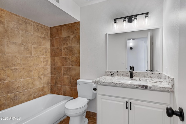 full bathroom with tiled shower / bath combo, toilet, tile patterned floors, and vanity