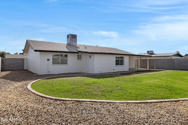 back of property featuring central AC and a yard