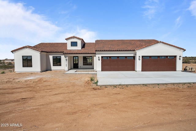 34198 S State Route 89th Hwy, Wickenburg, AZ 85390 - mediterranean / spanish house featuring a tile roof, a garage, stucco siding, and driveway