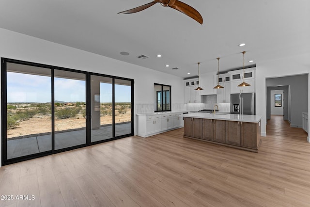 34198 S State Route 89th Hwy, Wickenburg, AZ 85390 - kitchen featuring stainless steel refrigerator with ice dispenser, light countertops, white cabinets, light wood finished floors, and recessed lighting