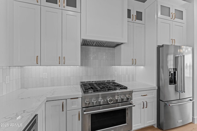 34198 S State Route 89th Hwy, Wickenburg, AZ 85390 - kitchen with premium appliances, white cabinets, light stone countertops, and tasteful backsplash