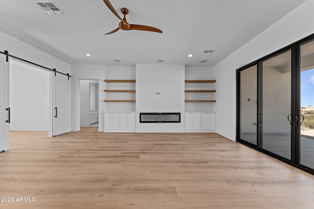 34198 S State Route 89th Hwy, Wickenburg, AZ 85390 - unfurnished living room with ceiling fan, a barn door, light wood finished floors, recessed lighting, and baseboards