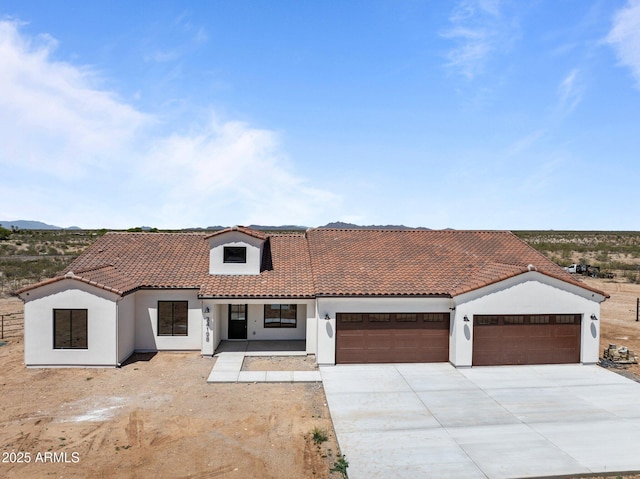 34198 S State Route 89th Hwy, Wickenburg, AZ 85390 - mediterranean / spanish-style home featuring an attached garage, stucco siding, concrete driveway, and a tiled roof