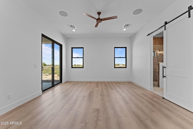 34198 S State Route 89th Hwy, Wickenburg, AZ 85390 - unfurnished bedroom with a barn door, access to exterior, multiple windows, light wood-style flooring, and recessed lighting