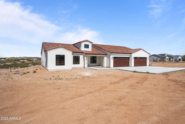 34198 S State Route 89th Hwy, Wickenburg, AZ 85390 - mediterranean / spanish-style home with a garage, concrete driveway, a tiled roof, and stucco siding