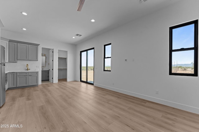34198 S State Route 89th Hwy, Wickenburg, AZ 85390 - unfurnished living room featuring light wood finished floors, baseboards, a sink, recessed lighting, and ceiling fan