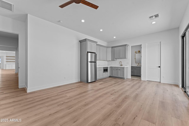 34198 S State Route 89th Hwy, Wickenburg, AZ 85390 - unfurnished living room featuring ceiling fan, recessed lighting, light wood finished floors, a sink, and baseboards