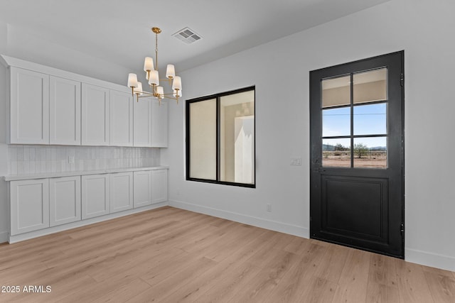 34198 S State Route 89th Hwy, Wickenburg, AZ 85390 - unfurnished dining area featuring a chandelier, light wood-type flooring, and baseboards