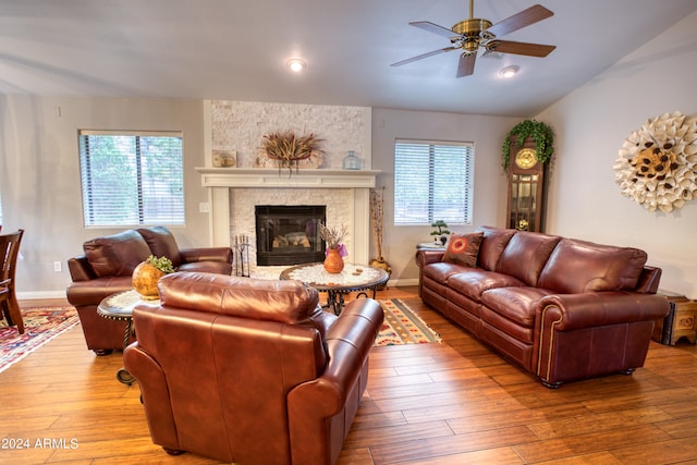 living room with lofted ceiling, a large fireplace, ceiling fan, and hardwood / wood-style floors