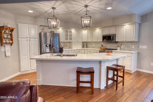 kitchen featuring white cabinets, appliances with stainless steel finishes, decorative backsplash, and light hardwood / wood-style floors