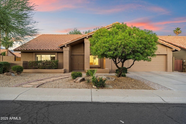 13361 N 99th Pl, Scottsdale, AZ 85260 - view of front of home with a tiled roof, a garage, stucco siding, and driveway