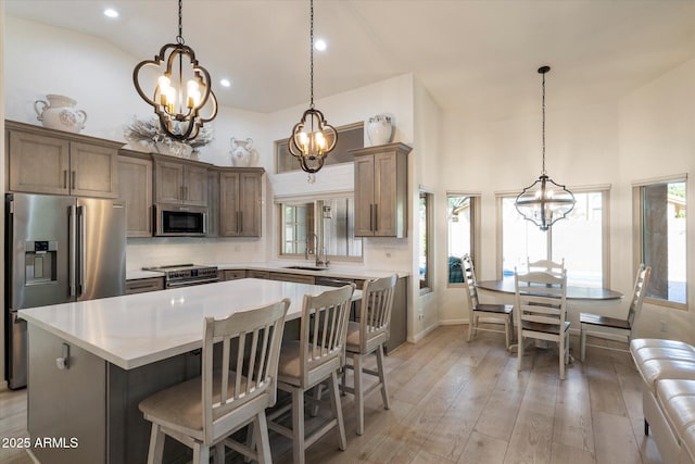 13361 N 99th Pl, Scottsdale, AZ 85260 - kitchen featuring a chandelier, appliances with stainless steel finishes, a sink, healthy amount of natural light, and high vaulted ceiling