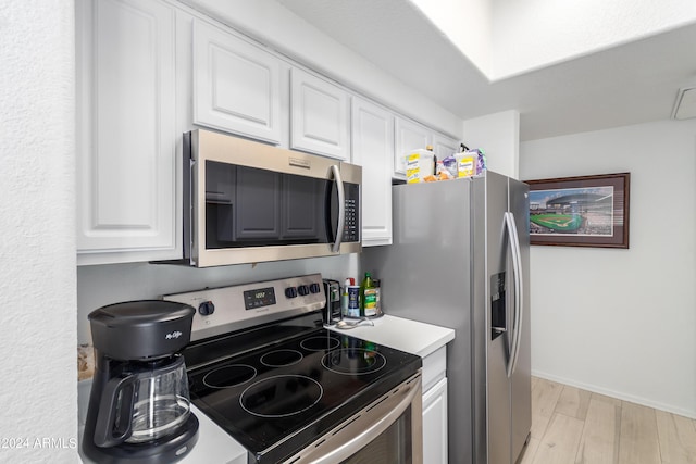 kitchen with white cabinetry, light hardwood / wood-style flooring, and appliances with stainless steel finishes