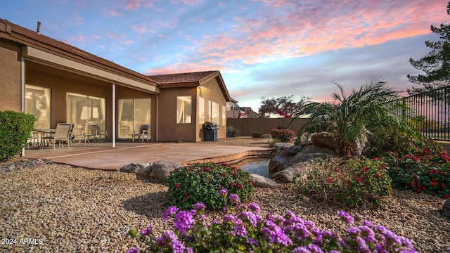 yard at dusk featuring a patio