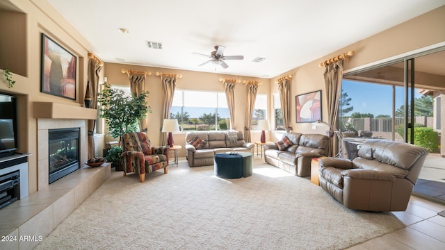 living room with ceiling fan, light tile patterned floors, and a tiled fireplace