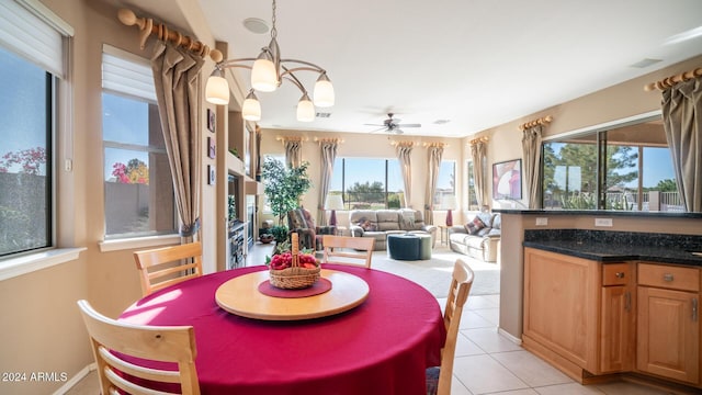 dining space featuring light tile patterned floors and ceiling fan with notable chandelier