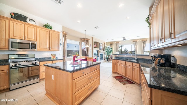 kitchen featuring sink, a kitchen island, stainless steel appliances, and light tile patterned floors