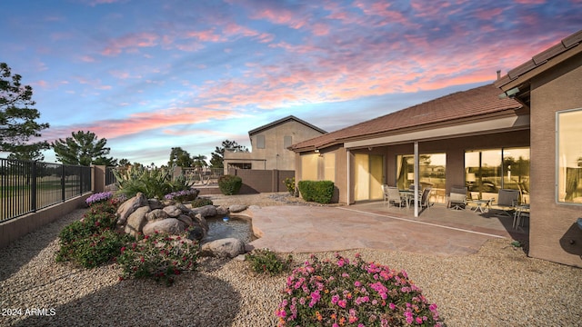 yard at dusk featuring a patio area