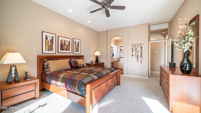 bedroom with connected bathroom, ceiling fan, and light colored carpet