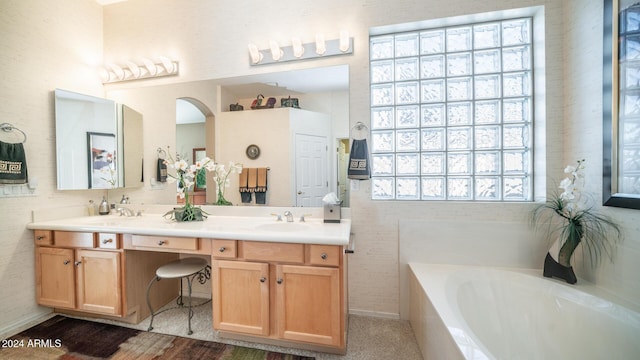 bathroom with vanity and a relaxing tiled tub