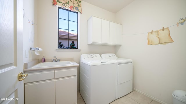 clothes washing area featuring cabinets, light tile patterned floors, washing machine and dryer, and sink