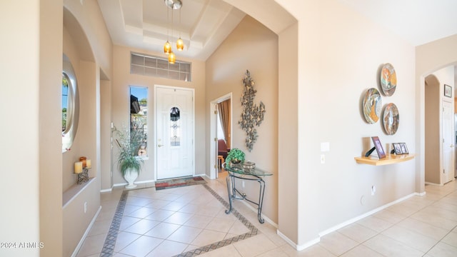 entrance foyer featuring light tile patterned floors and a tray ceiling