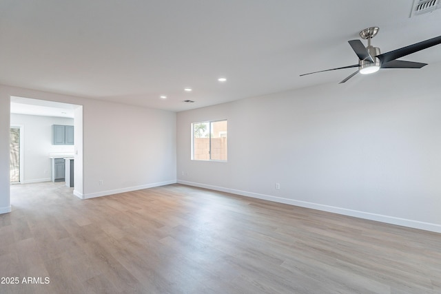 empty room featuring ceiling fan and light hardwood / wood-style floors