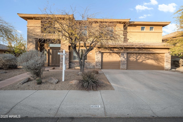 view of front of house featuring stone siding, driveway, and stucco siding