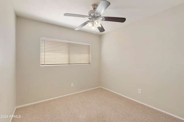 empty room with ceiling fan, a textured ceiling, and carpet floors