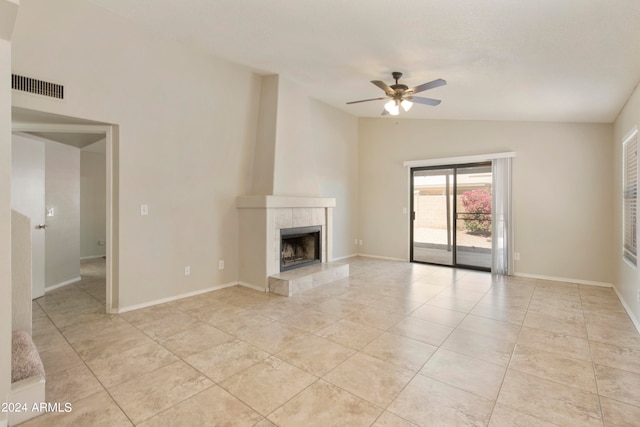 unfurnished living room with ceiling fan, light tile patterned floors, a fireplace, and vaulted ceiling