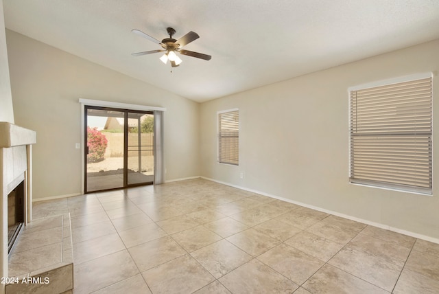 tiled empty room featuring a premium fireplace, ceiling fan, and lofted ceiling