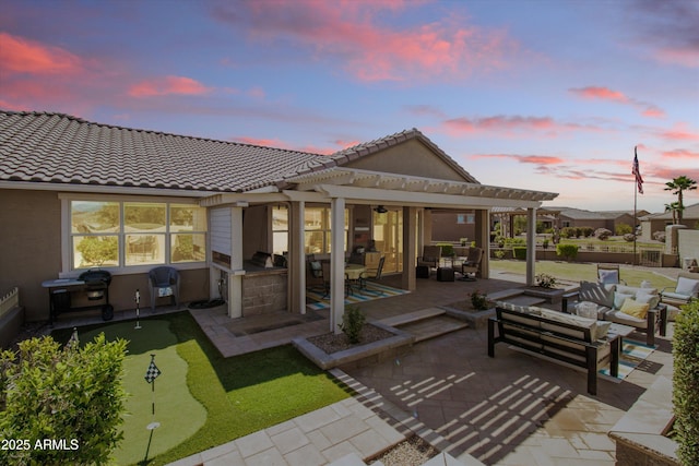 back of house featuring a pergola, a patio, an outdoor hangout area, exterior kitchen, and a tile roof