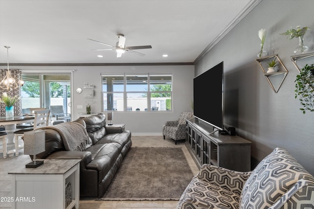 living room with baseboards, ornamental molding, ceiling fan with notable chandelier, and recessed lighting
